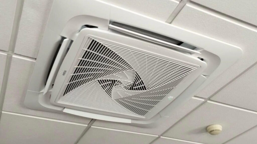 Unidade interior de ar condicionado tipo cassete instalada num teto falso com painéis modulares